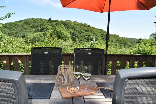 a table with two glasses of wine and an umbrella at De Oranje Kabouter in Durbuy