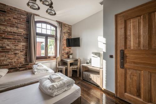 a room with two beds and a brick wall at Stara Przepompownia in Ostrów Wielkopolski