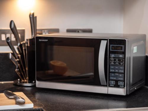 a microwave sitting on top of a kitchen counter at Central Birmingham Apartment with Balcony & Netflix in Birmingham