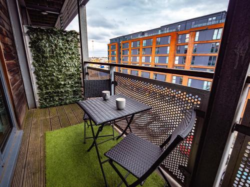a balcony with a table and chairs and a building at Central Birmingham Apartment with Balcony & Netflix in Birmingham
