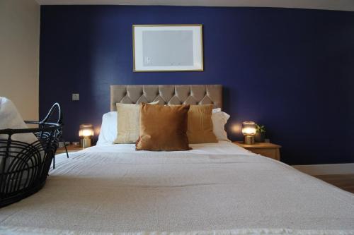 a bedroom with a large bed with a blue wall at Central Birmingham Apartment with Balcony & Netflix in Birmingham