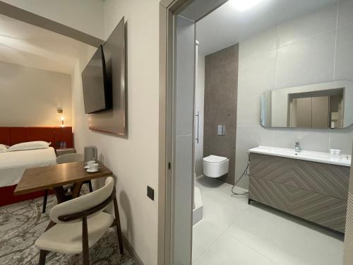a bathroom with a bed and a desk and a sink at Naya Hotel in Almaty