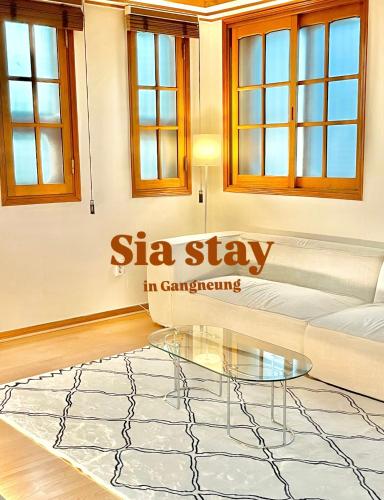 a living room with a sofa and a glass table at Gangneung Sia Stay in Gangneung