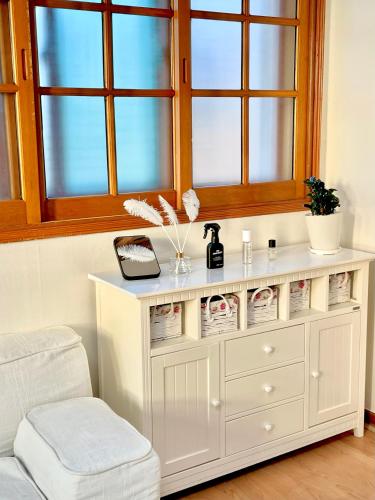 a white dresser in a living room with a window at 강릉 44평 복층 독채 시아스테이 Gangneung Sia Stay in Gangneung