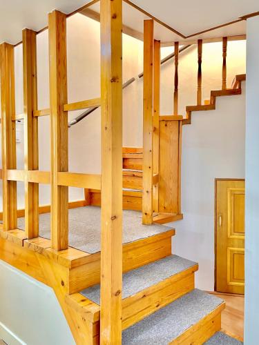 a wooden staircase in a home with wooden stairs and wooden floors at 강릉 44평 복층 독채 시아스테이 Gangneung Sia Stay in Gangneung