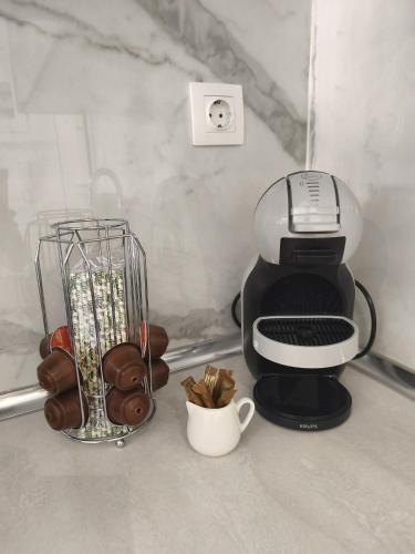 a coffee maker on a counter next to a cup of coffee at Tommys Apartment in Nei Poroi