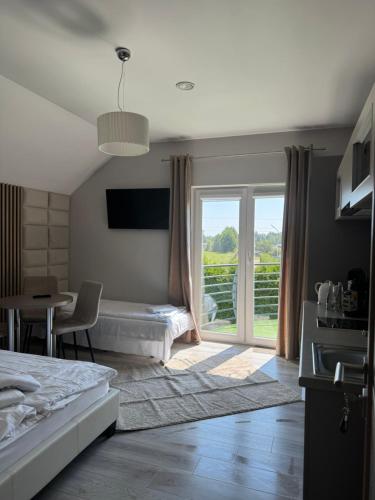 a bedroom with a bed and a window and a table at Platinium in Karwia
