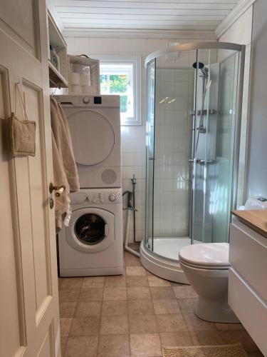 a bathroom with a washing machine and a shower at Mølleråsen Apartment in Sandefjord