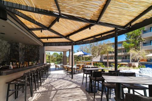 an outdoor restaurant with tables and chairs and a wooden roof at Cabú Hotel - Adults Only in Faliraki