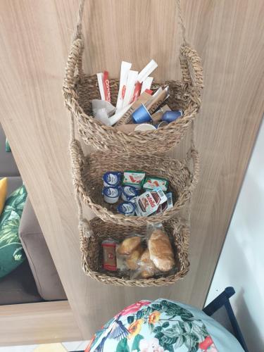 deux paniers sur une étagère avec de la nourriture et du pain dans l'établissement La Tropicale, studio climatisé avec parking, Proche Cité médiévale, à Carcassonne