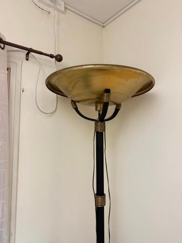 a brass lamp on a pole against a wall at וילה נקודה בכנרת in Had Nes