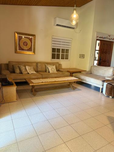 a living room with a couch and a bed at וילה נקודה בכנרת in Had Nes