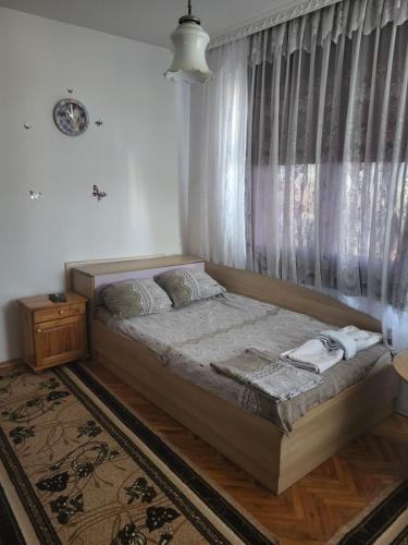 a bed in a room with a window and a bed sidx sidx sidx at Апартамент Стоянови in Primorsko