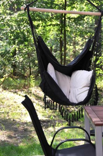 a black hammock with white pillows in a yard at Daleko od Szosy in Krajęczyn