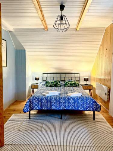 a bedroom with a bed with a blue comforter at Daleko od Szosy in Krajęczyn