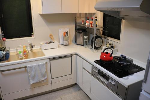 a kitchen with a red tea kettle on the stove at Chiyoda-Home　Osu-sakae-Subways-JR trin-Spa-parking spot-WIFI in Nagoya
