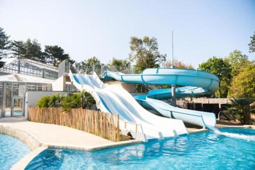 a water slide in a pool at a resort at Mobil home 6 personnes Mer et Pins in Piriac-sur-Mer