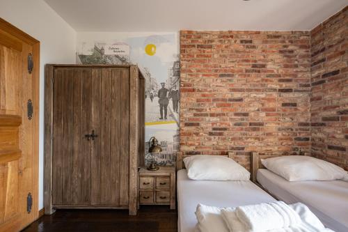 two beds in a room with a brick wall at Stara Przepompownia in Ostrów Wielkopolski