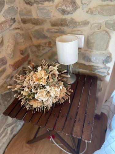 a table with a lamp and a bouquet of flowers at Il Tesoro di MiRo in Cartosio