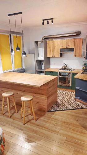 a kitchen with a large wooden table and two stools at Na Chopina in Krapkowice