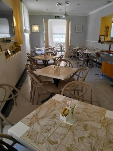 a restaurant with wooden tables and chairs and tablesktop at Allegro Hotel in St Julian's