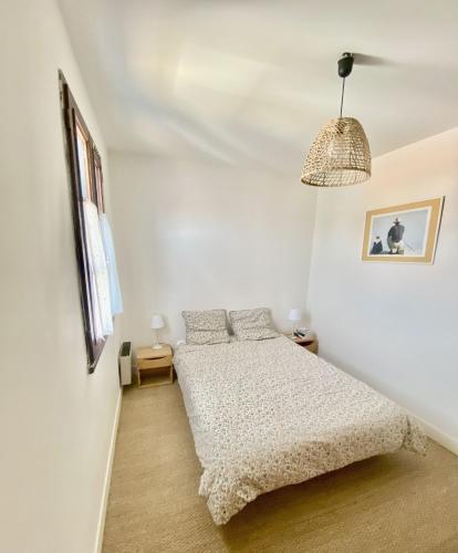 une chambre blanche avec un lit et une fenêtre dans l'établissement Maison de vacances à l'Ile d'Yeu - Les Genêts, à L'Ile d'Yeu