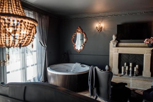 a bath tub in a room with a fireplace at Hazai Provence in Kapolcs