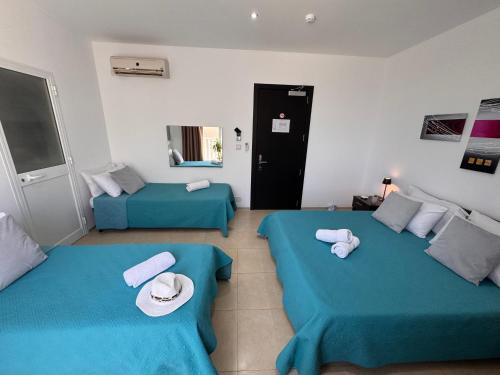two beds in a room with blue sheets and towels at Allegro Hotel in St Julian's