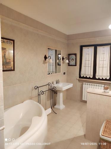 a white bathroom with a tub and a sink at La Fattoria Di Mamma Ro' in Narni