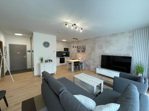 a living room with a blue couch and a table at Brezovina Breza B115 in Veselé