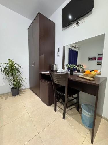 a kitchen with a desk and a table with fruits on it at Allegro Hotel in St Julian's