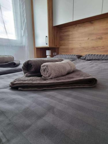 three towels are laying on a bed in a room at Bella LUX in Modriča