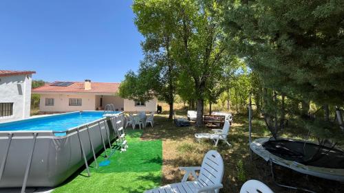 a backyard with a swimming pool and chairs and trees at LA MINA Alojamiento en plena naturaleza in Garganta de los Montes
