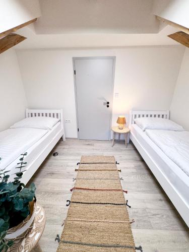 two beds in a room with a door at Chalet Pasečná in Přední Výtoň