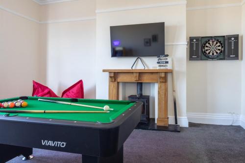 a room with a pool table and a tv at Entire Home on Beach Front, Sleeps 25 with Free Parking in Rhyl