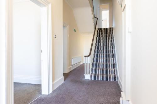 an empty hallway with a staircase in a house at Entire Home on Beach Front, Sleeps 25 with Free Parking in Rhyl