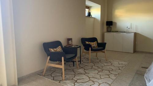 two blue chairs and a table in a room at Casa do Cruzeiro in Alvações do Corgo