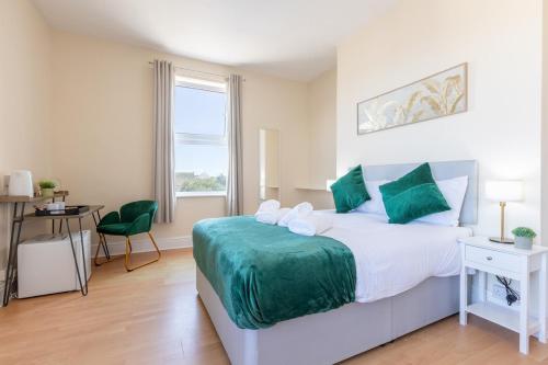 a bedroom with a bed and a table and a window at Entire Home on Beach Front, Sleeps 25 with Free Parking in Rhyl