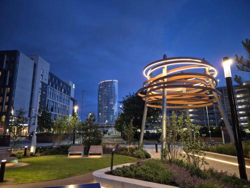 ベルファストにあるHigh Rise Luxury, Belfastの夜のベンチと金属構造物のある公園