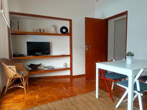 a living room with a white table and a television at Combatentes Apartment in Porto