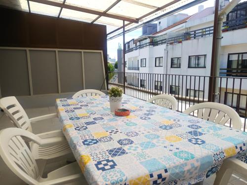 a table with chairs and a quilt on a balcony at Combatentes Apartment in Porto