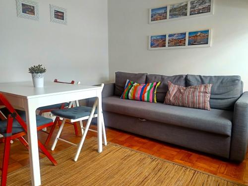 a living room with a couch and a table and a table and chairs at Combatentes Apartment in Porto