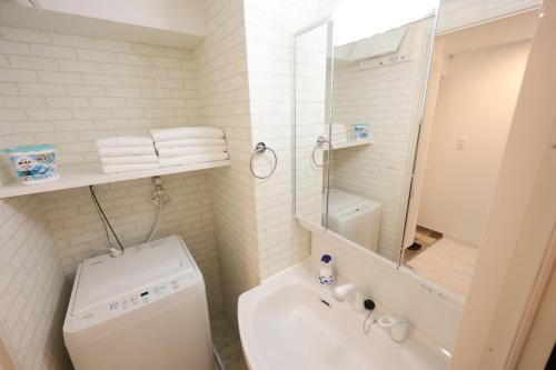 a white bathroom with a toilet and a sink at The Marina Bay in Fukuoka