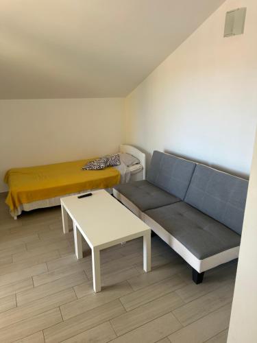 a room with a couch and a bed and a table at Villa Dragic in Brodarica