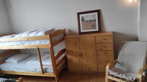 - une chambre avec des lits superposés, une commode et une chaise dans l'établissement APPARTEMENT F3 DUPLEX CENTRE-VILLE FONT-ROMEU, à Font-Romeu-Odeillo-Via