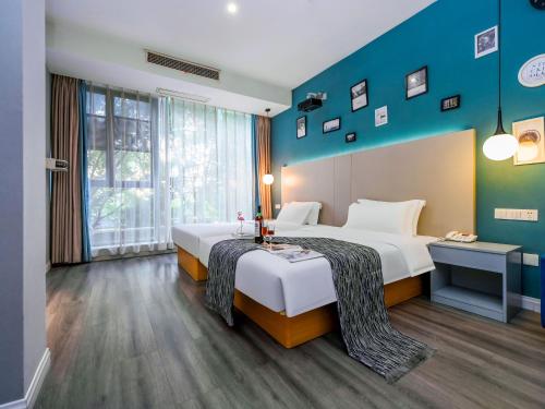 a bedroom with a large bed and a blue wall at 重庆莎霏酒店大渡口店 in Chongqing