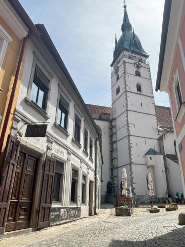 a building with a clock tower on a street at Udírna Penzion and Restaurant in Jindrichuv Hradec