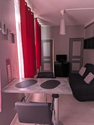 - un salon avec des rideaux rouges et une table dans l'établissement Studio Saint Pierre, à Ault