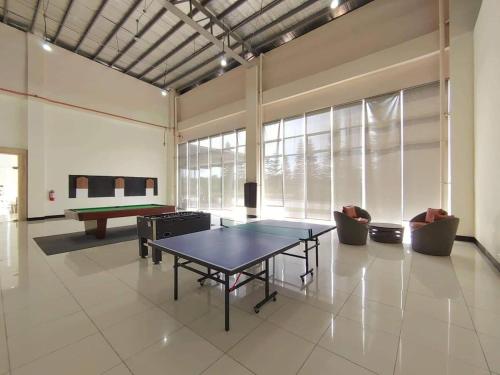 Großes Zimmer mit einer Tischtennisplatte und Stühlen in der Unterkunft JFC Inspired Stays PH - Wind Residences Tagaytay in Upli