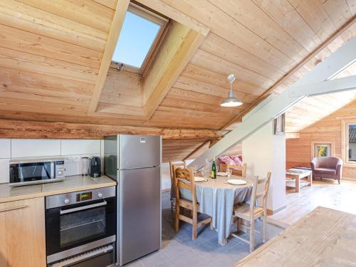 une cuisine et une salle à manger avec une table et un réfrigérateur dans l'établissement Bel Appartement au Centre de Chamonix, à 350m des Pistes, Parking et Services Inclus - FR-1-343-200, à Chamonix-Mont-Blanc
